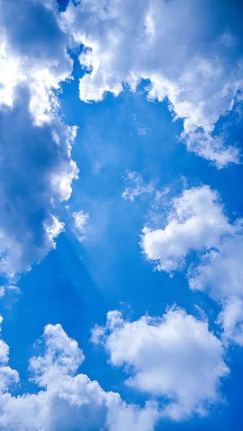 This may contain: an airplane is flying through the blue sky with white clouds in the backround